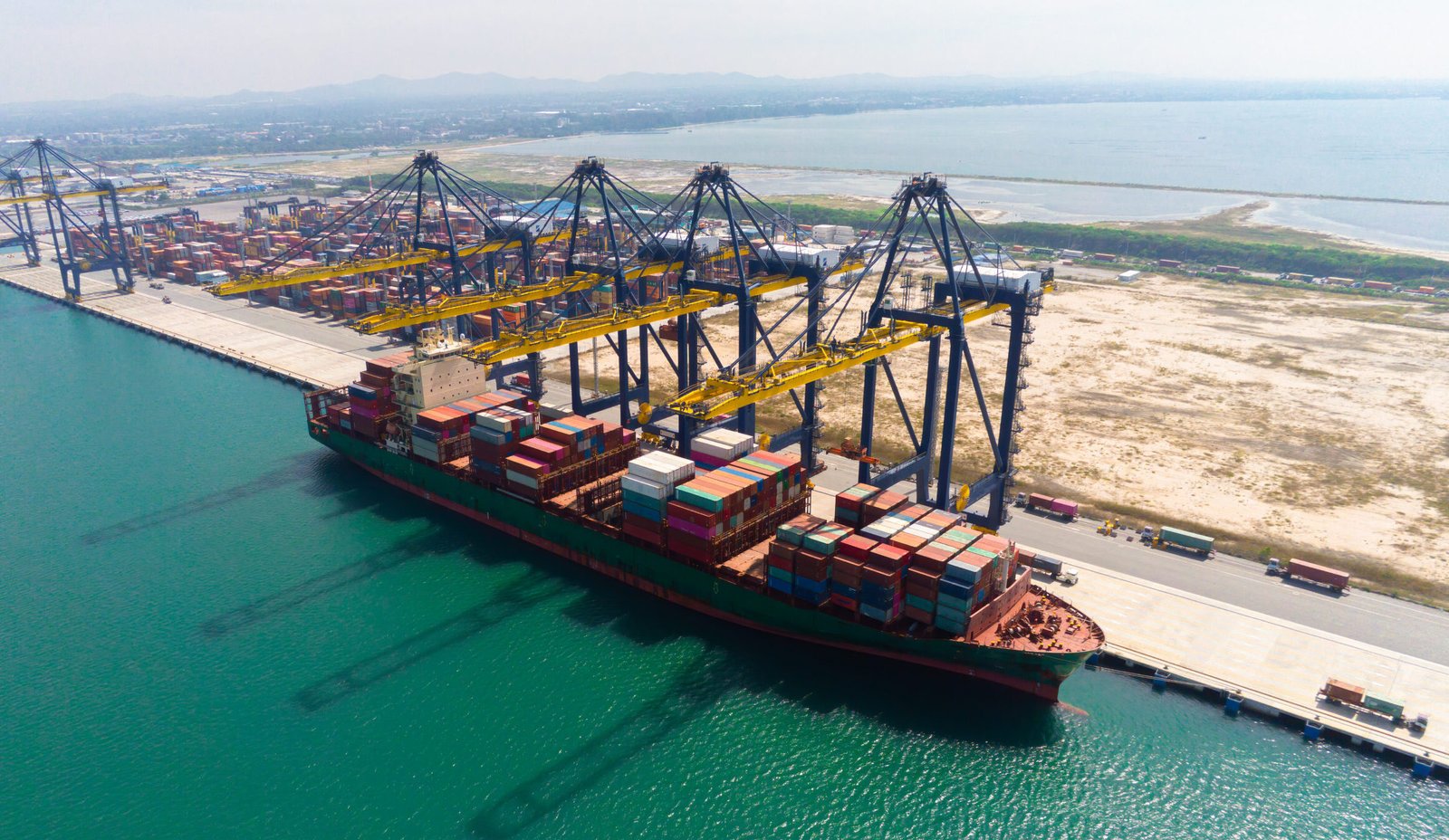 Commercial cargo container vessel facilitating shipping in Oman at port terminal